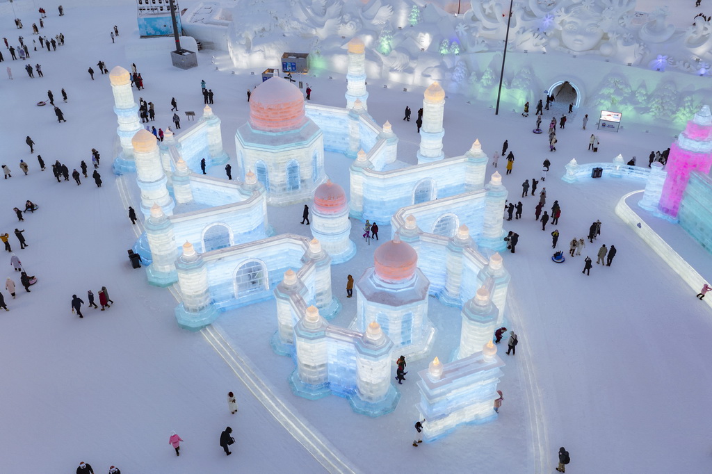 1月5日，在哈尔滨冰雪大世界园区，游客在一处大型冰建景观附近游玩（无人机照片）。新华社记者 谢剑飞 摄