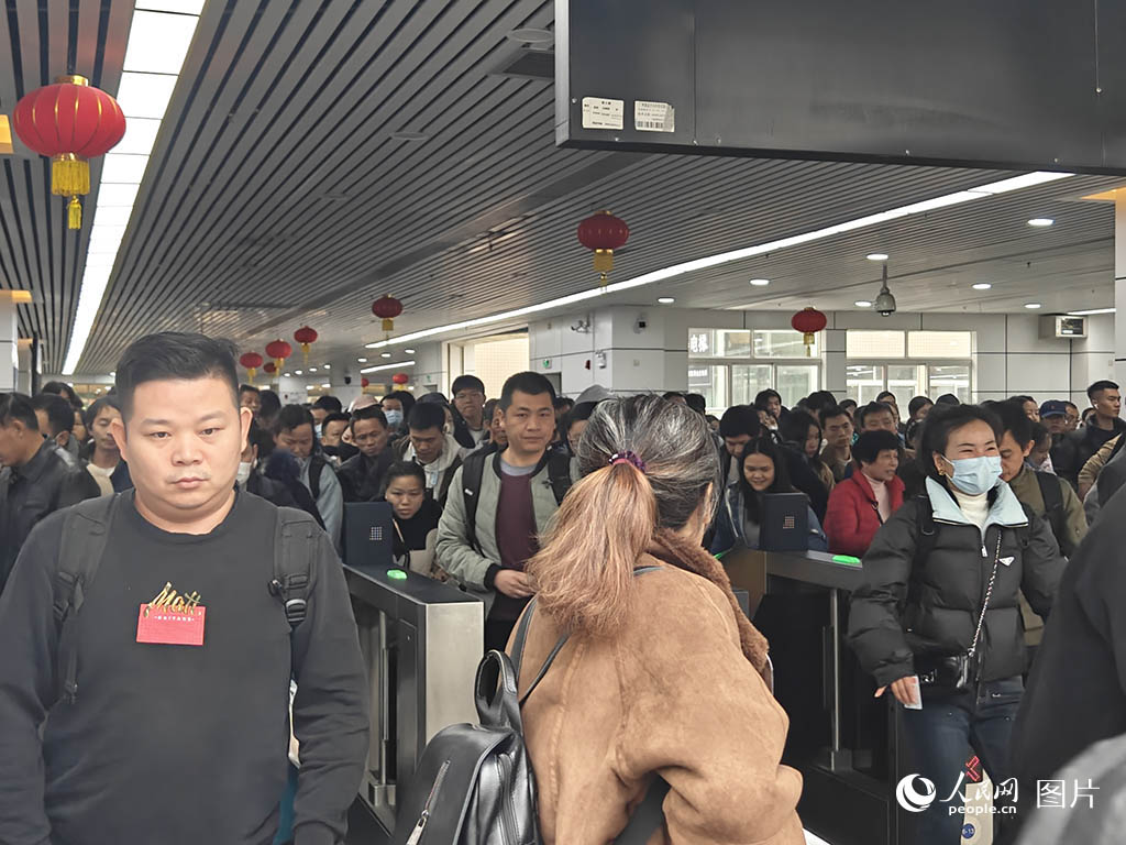 2025年春运首日，广州火车站内，旅客搭乘列车。人民网 王雅蝶摄