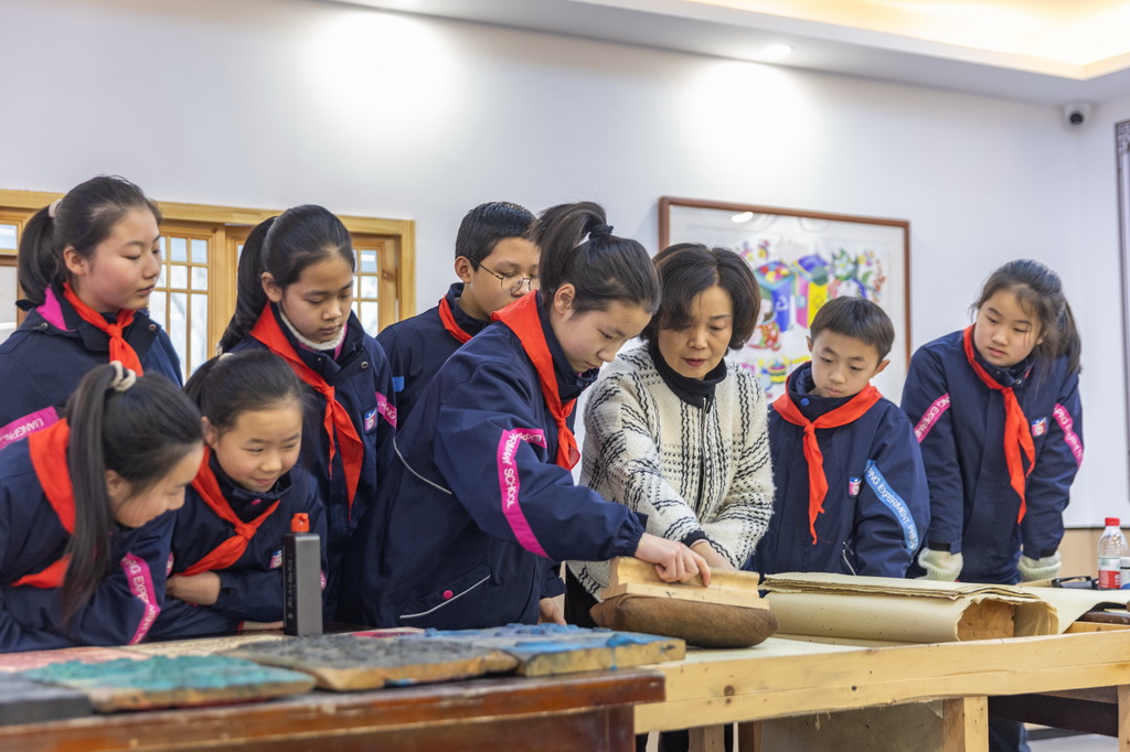 1月15日，在重庆市梁平区梁平实验小学少儿年画馆，梁平木版年画市级代表性传承人莫绍萍指导学生们学习梁平木版年画的刷印。