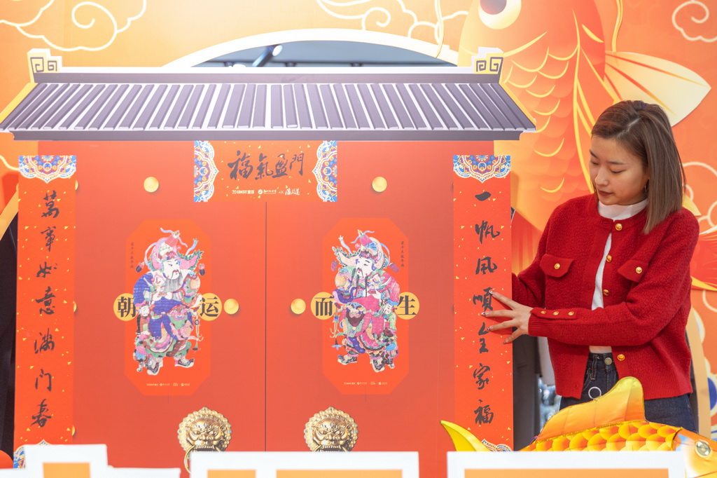 1月15日，在重庆市梁平区一商场，商场工作人员在摆放带有梁平木版年画元素的新春装饰。
