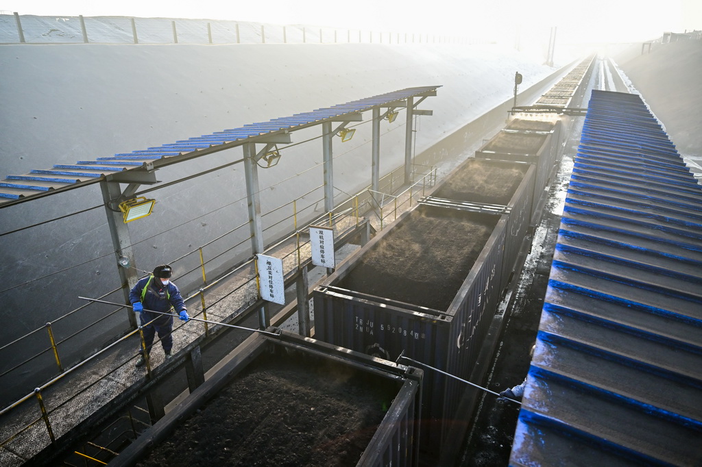 在新疆准东经济技术开发区内的新疆宜化矿业有限公司煤矿快装站，工作人员清理出疆货运列车上的煤渣（1月20日摄）。