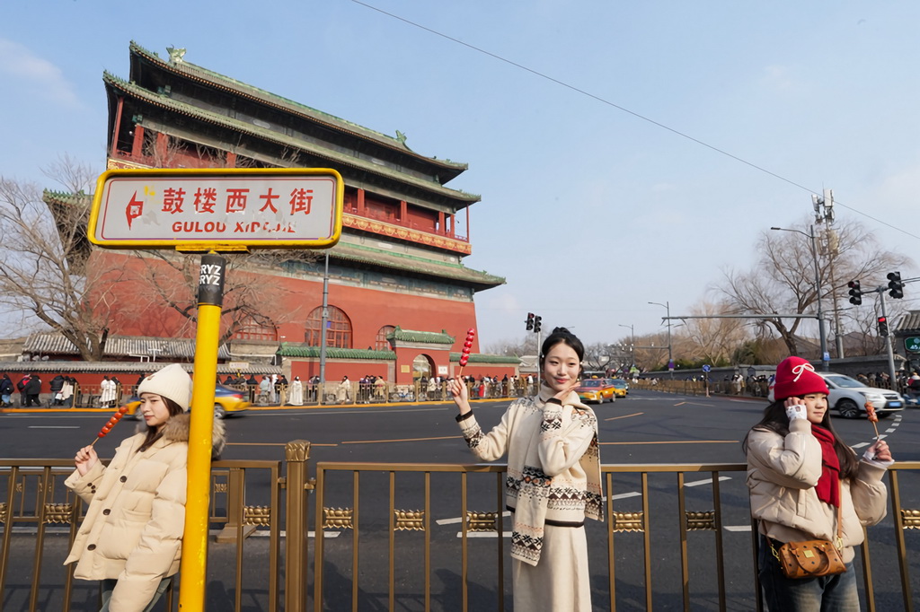 1月31日，游客在位于北京中轴线上的鼓楼前拍照留念。新华社记者 鞠焕宗 摄