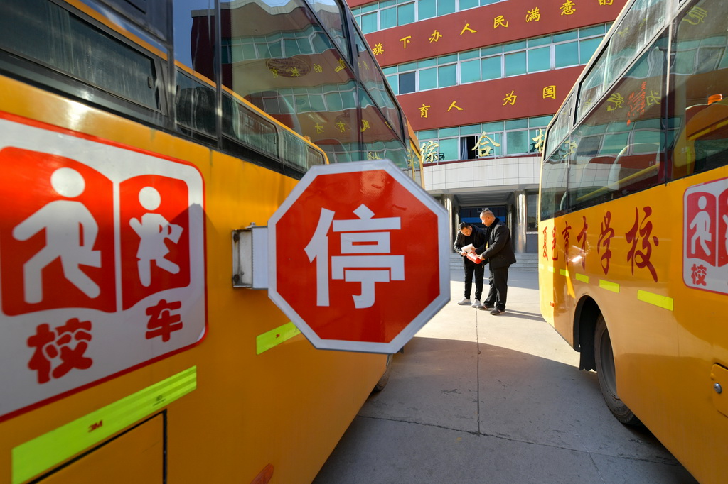 2月10日，河南省商丘市夏邑县育才学校校车安全员和驾驶员检查车辆状况。新华社发（苗育才摄）