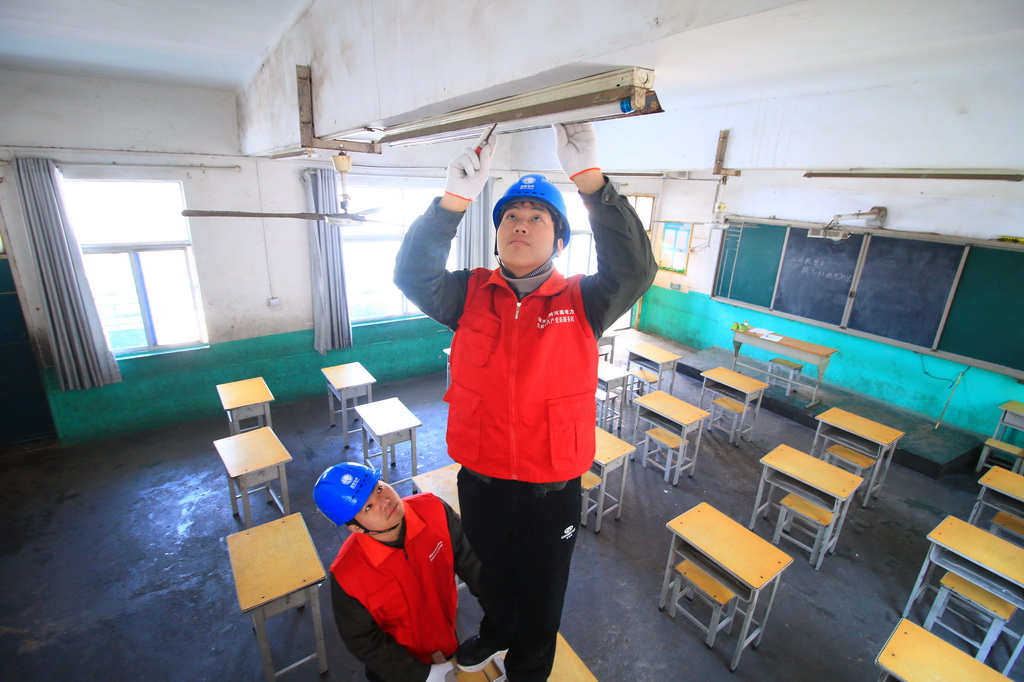2月10日，在河南省洛阳市汝阳县小店镇马庄村小学，供电公司工作人员检查教室用电线路。新华社发（康红军摄）