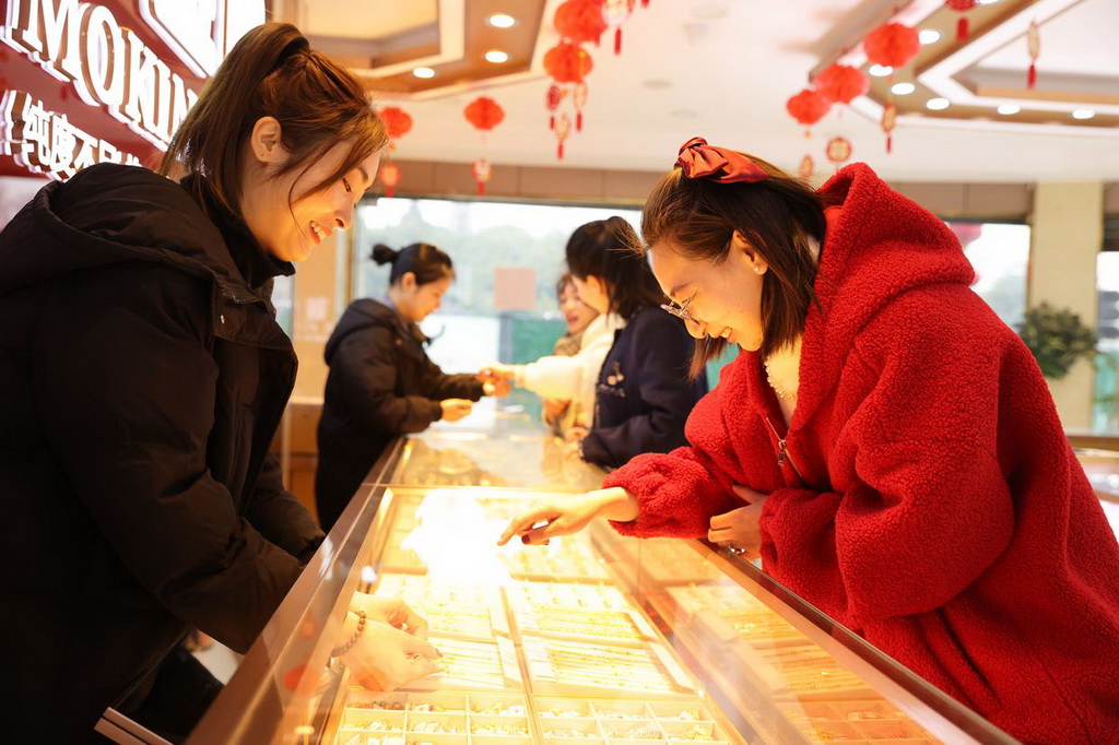2月11日，顾客在浙江省湖州市德清县乾元镇一家金店挑选黄金首饰。