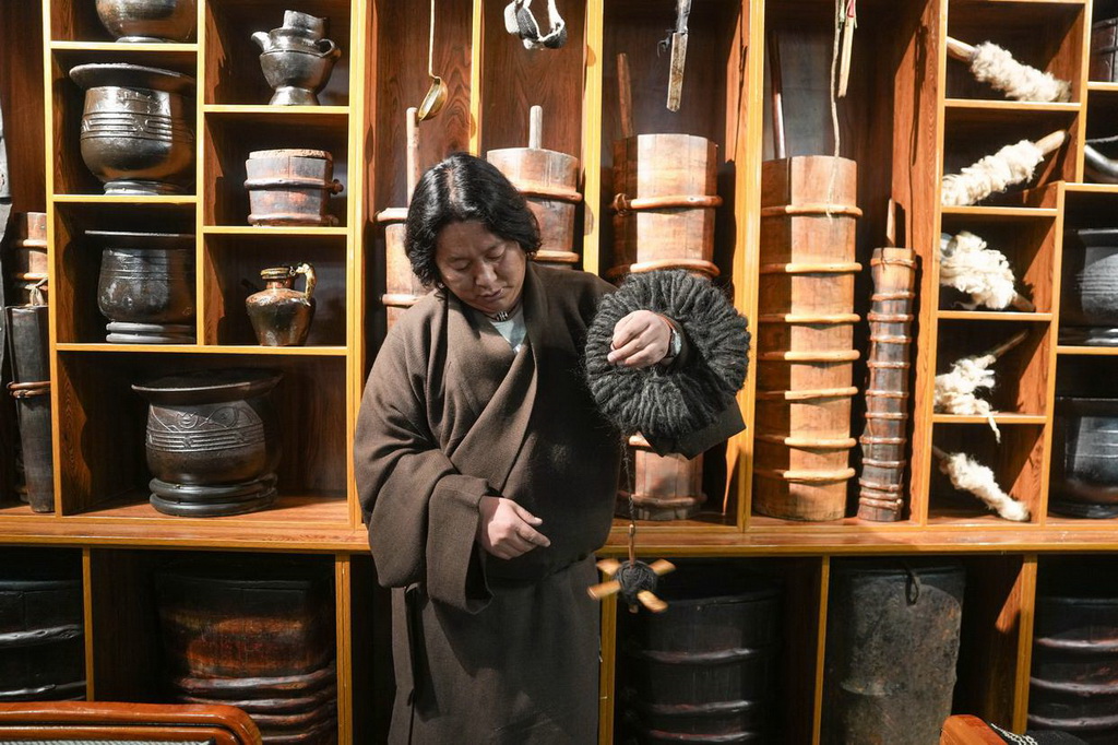 “牧人宝库”藏式茶馆主人珠珠演示纺羊毛线用的工具（2月13日摄）。