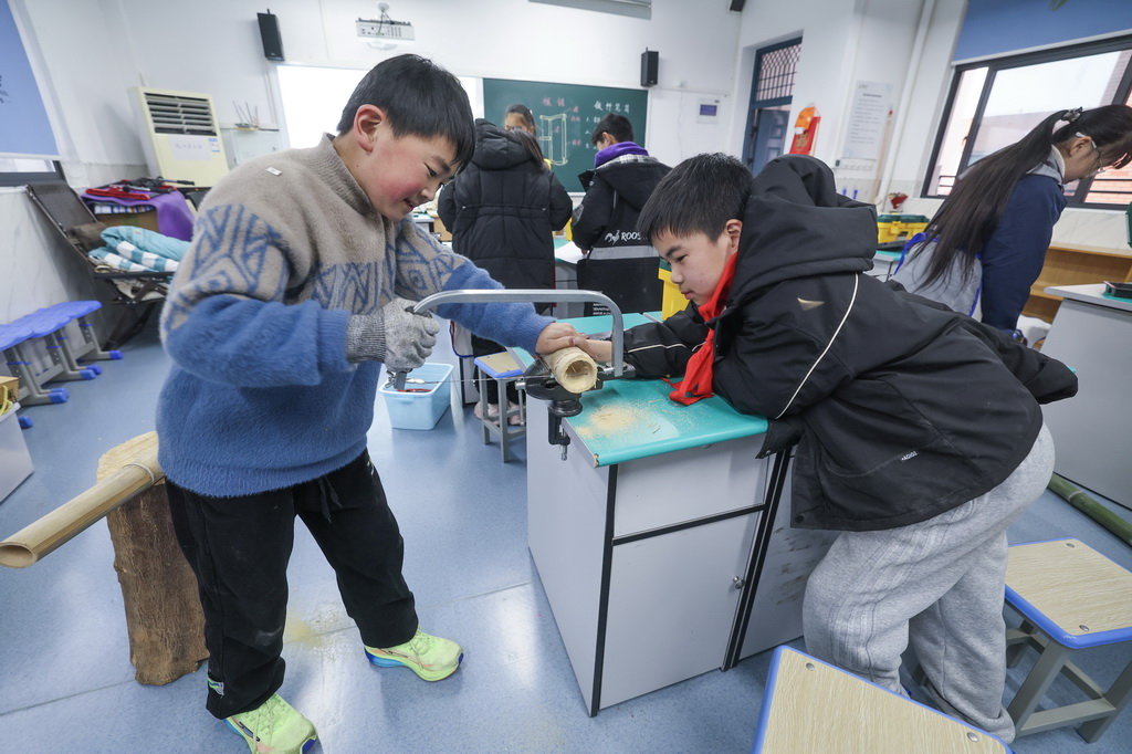2月19日，诸暨市暨南街道暨南小学的学生们在拓展性课程木工课上学习木工技能。