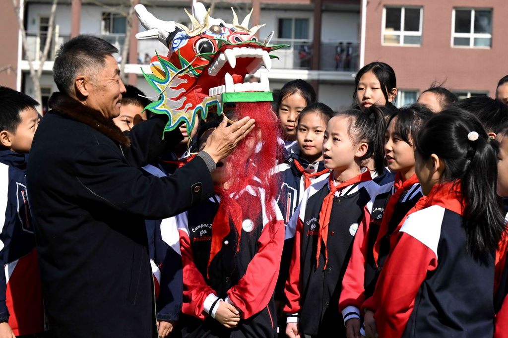 2月26日，王彦州在石家庄市草场街小学给孩子们讲解龙风筝制作技艺。新华社发（陈其保摄）