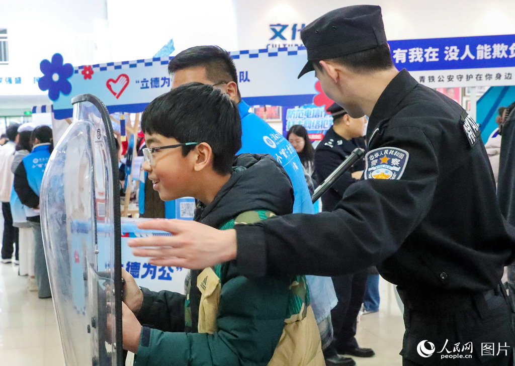 3月2日，一小朋友在青岛铁路公安处民警的指导下体验如何防卫。