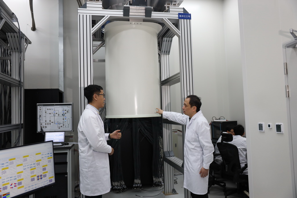3月3日，中国科学技术大学教授、“祖冲之号”量子计算总师朱晓波（右）与学生讨论制冷机状态。新华社发（代蕊摄）