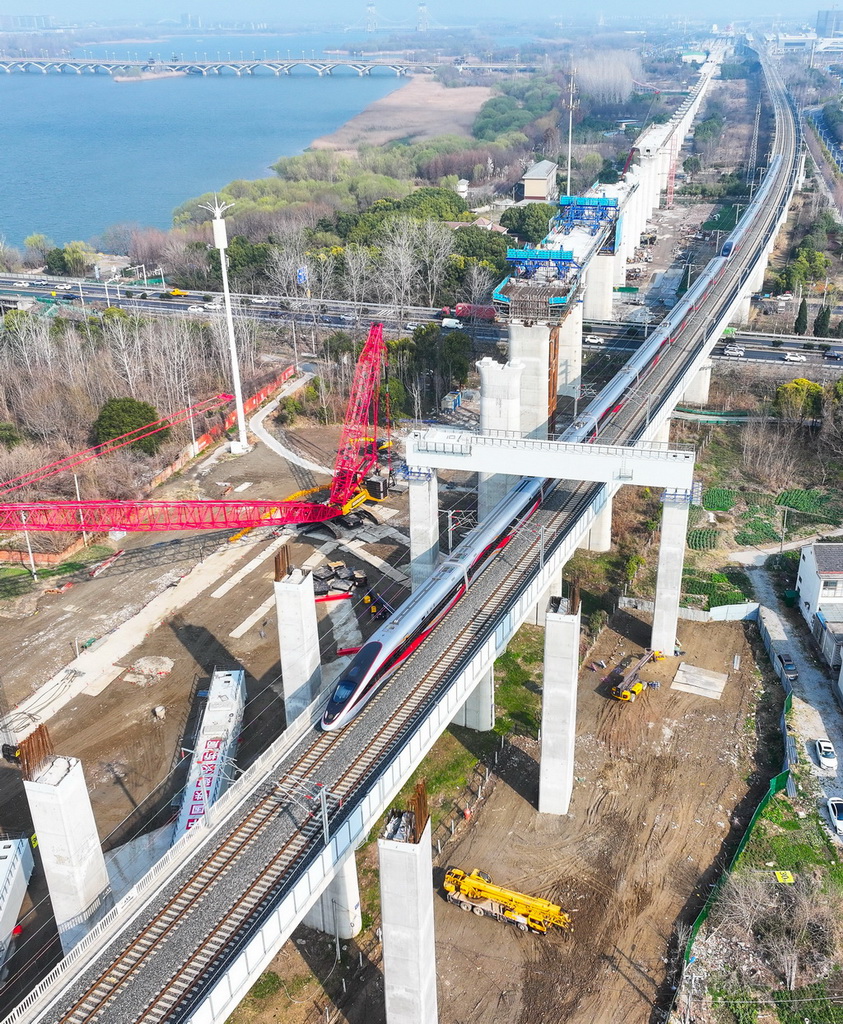 一列动车组列车从沪宁合高铁跨连镇高铁首跨钢横梁下通过（3月6日摄，无人机照片）。