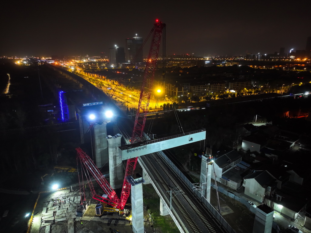 沪宁合高铁跨连镇高铁首跨钢横梁吊装作业现场（3月6日摄，无人机照片）。