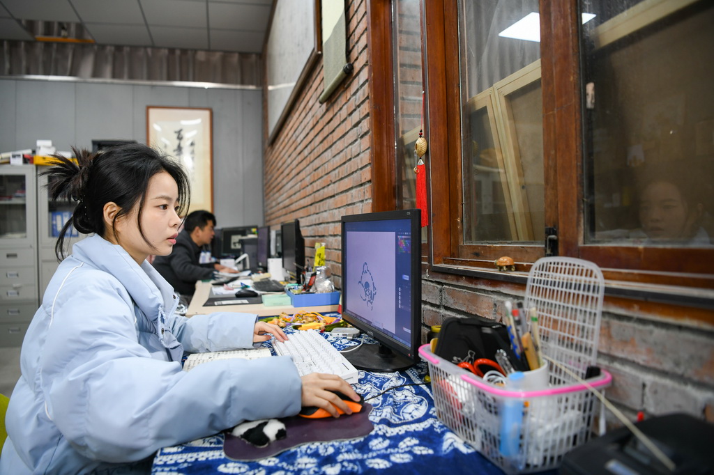 白梓忆（前）在电脑上设计完善熊猫文创形象细节（3月7日摄）。新华社记者 王曦 摄