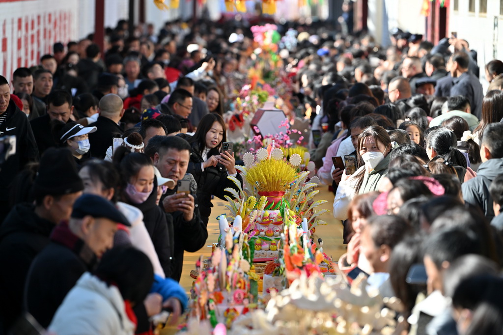 3月18日，在山西省岚县岚城镇，人们欣赏面塑作品。