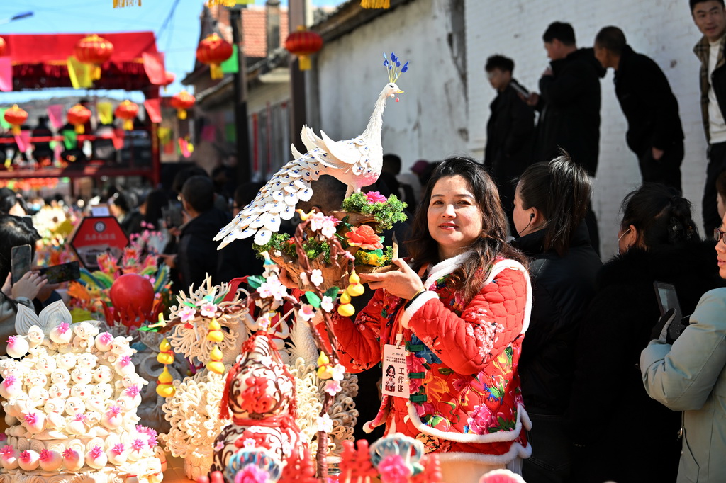 3月18日，在山西省岚县岚城镇，面塑师在展示自己的面塑作品。
