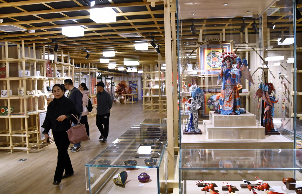 3月20日，人们在北京王府井工艺美术大厦内观看非遗文创产品展示。