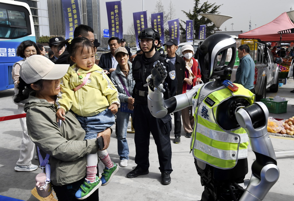 3月24日，警用机器人与群众互动。