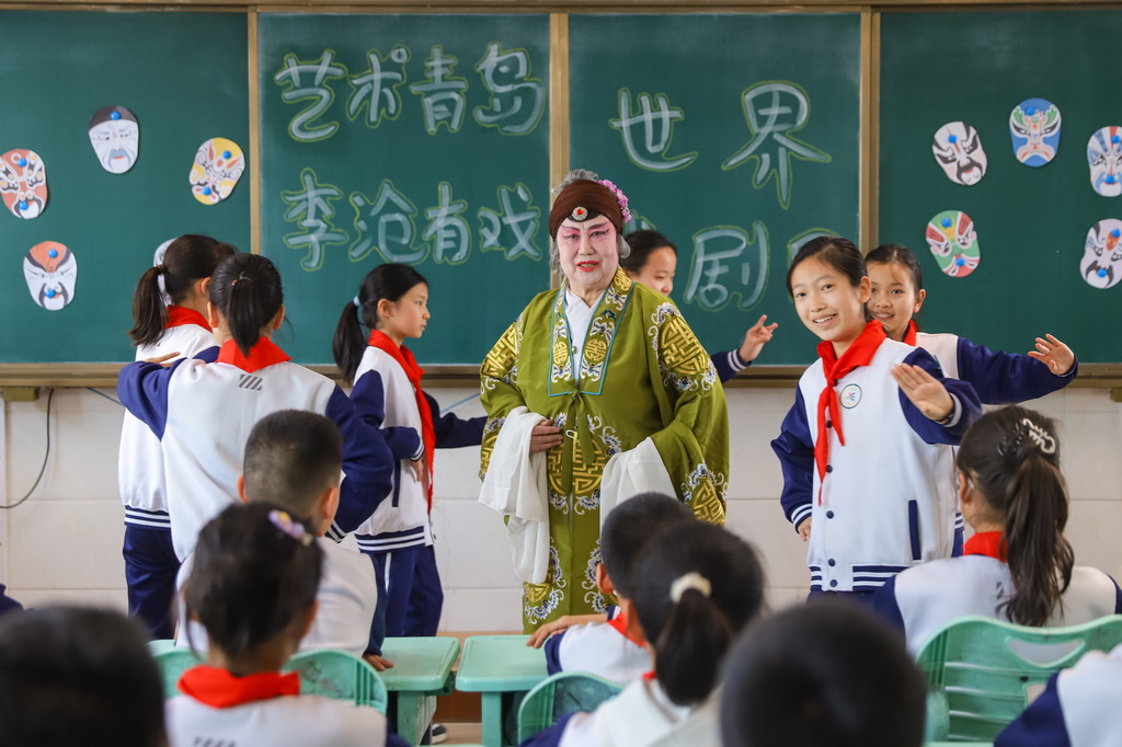 3月25日，在山东青岛北山小学开展的“艺术青岛·李沧有戏”主题活动中，柳腔演员指导学生戏曲动作。新华社发（张鹰摄）