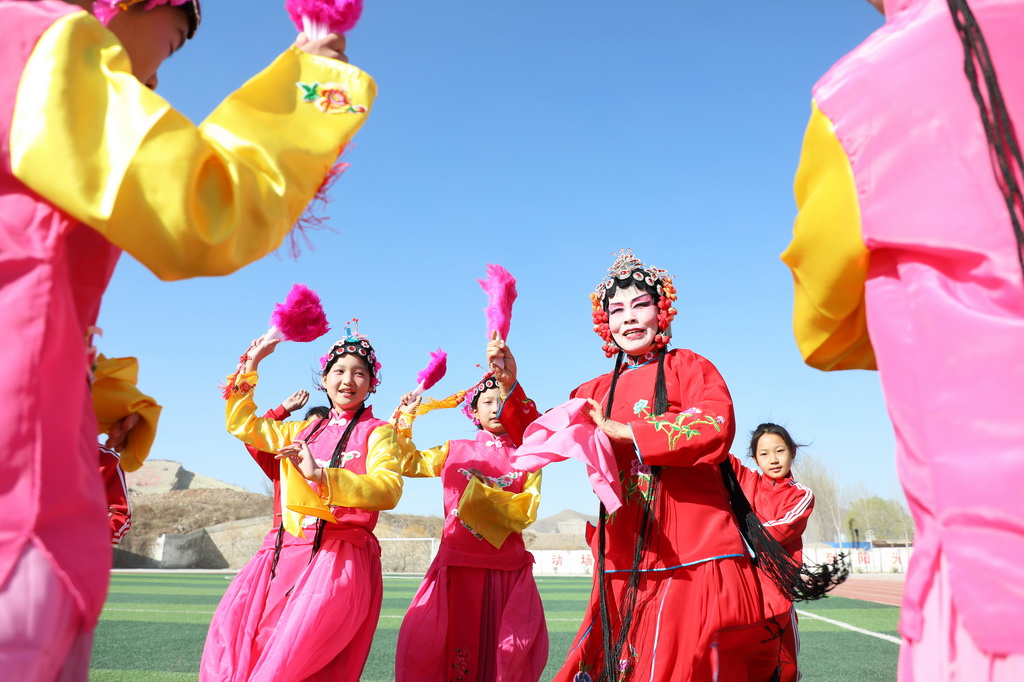 3月25日，在河北省唐山市丰润区泉河头镇团山子小学，评剧演员在教学生戏曲动作。新华社发（朱大勇摄）