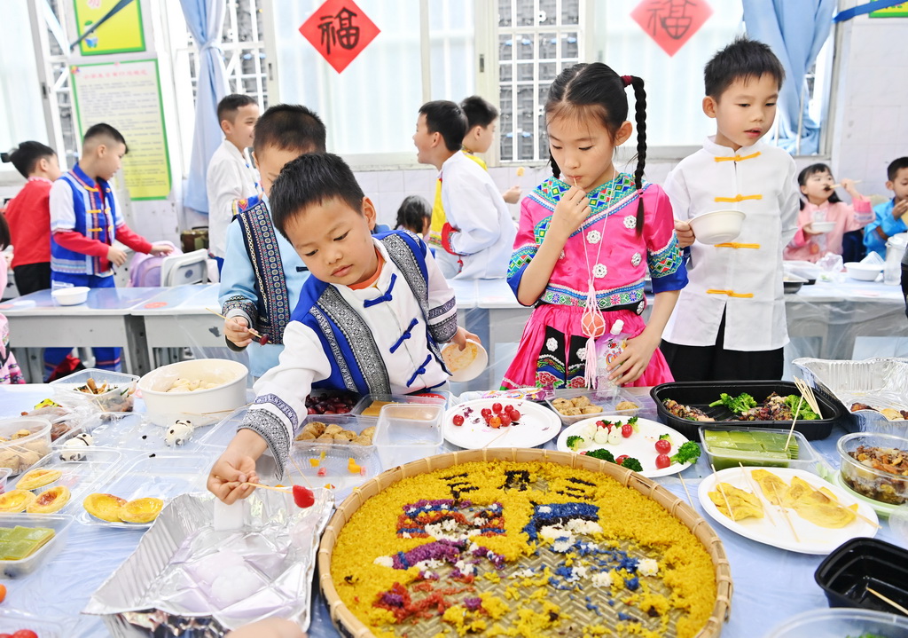 3月27日，孩子们在广西南宁市民族大道东段小学品尝传统美食。新华社记者 周华 摄