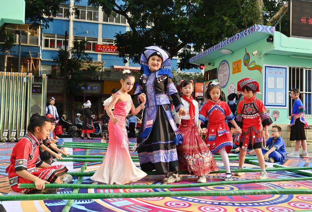 3月27日，老师和孩子们在广西南宁市民族大道东段小学跳竹竿舞。新华社记者 周华 摄