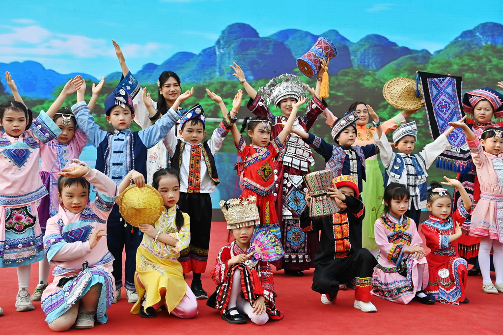 3月27日，孩子们在广西南宁市民族大道东段小学展示民族服装。新华社记者 周华 摄