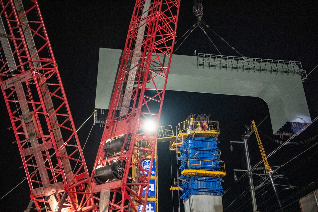 3月27日，在成达万高铁建设现场，施工人员在进行高铁钢横梁吊装作业。新华社记者 唐奕 摄