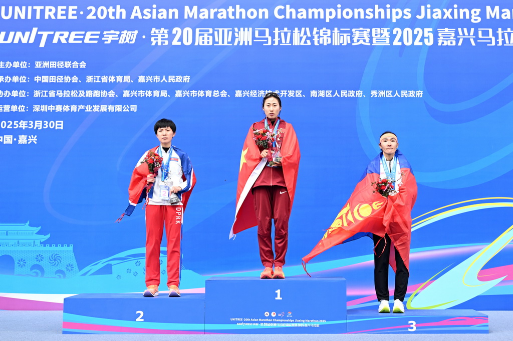 3月30日，第20届亚洲马拉松锦标赛女子组冠军中国选手吴冰（中）、亚军朝鲜选手李光玉（左）和季军蒙古国选手希希赛汗·加尔巴德拉赫也在颁奖仪式上。