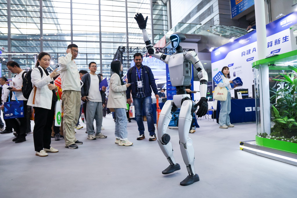 4月9日，观众在第十三届中国电子信息博览会上观看人形机器人展示。