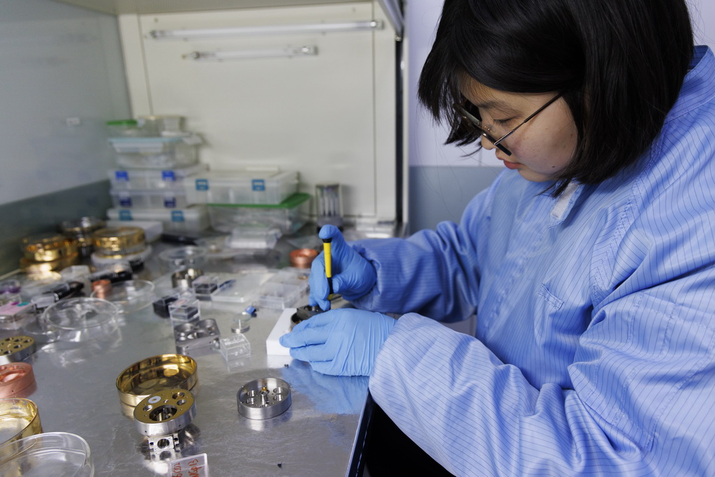 4月8日，在中国科学院地质与地球物理研究所纳米离子探针实验室，科研人员把即将进行实验检测的月球样品放进纳米离子探针样品靶台里。