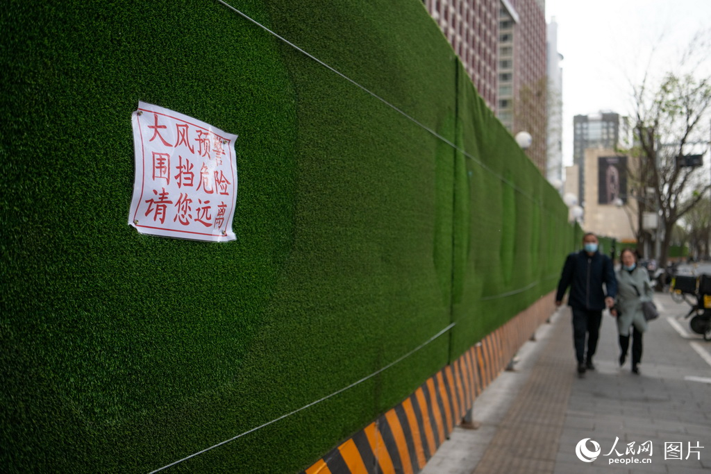4月12日，北京建国路一工地围墙上贴着“大风预警，围挡危险，请您远离”的提示。人民网记者 翁奇羽摄