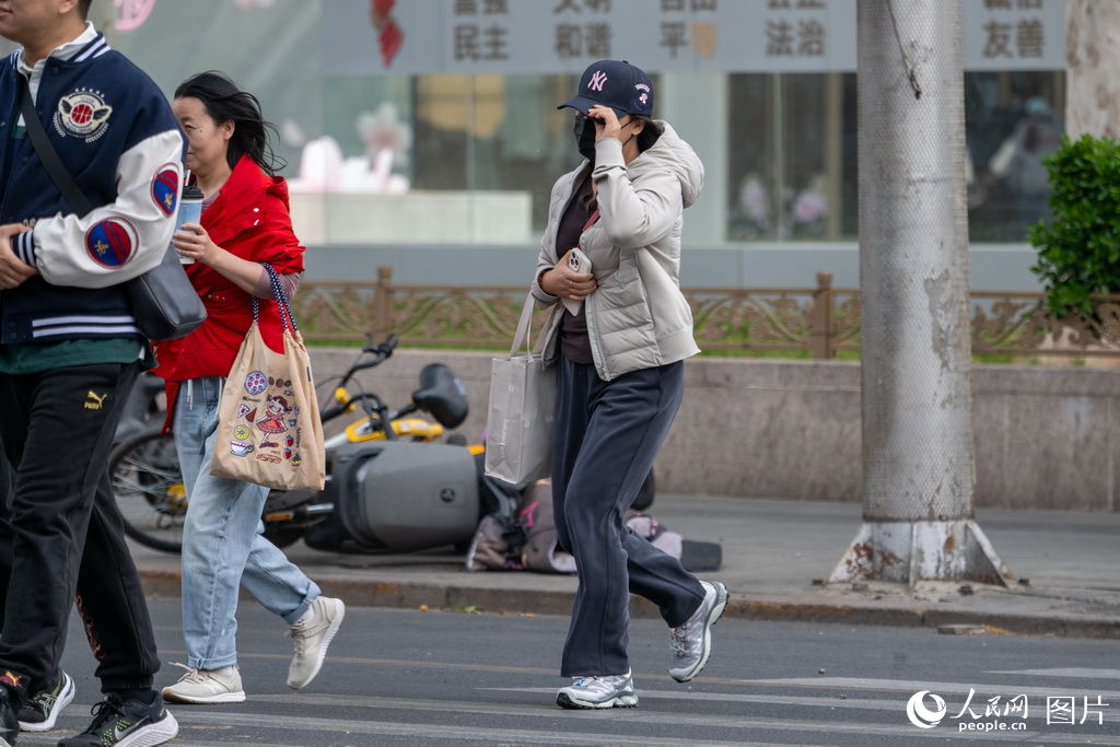 4月12日，北京西大望路，市民在大风中出行。人民网记者 翁奇羽摄