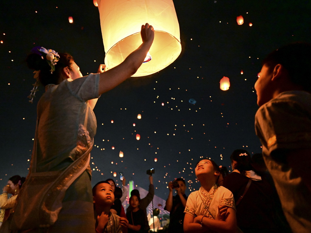 4月13日晚，人们在西双版纳傣族自治州景洪市澜沧江畔放飞孔明灯。