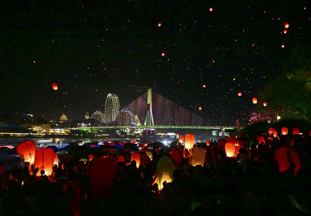 4月13日晚，人们在西双版纳傣族自治州景洪市澜沧江畔放飞孔明灯。