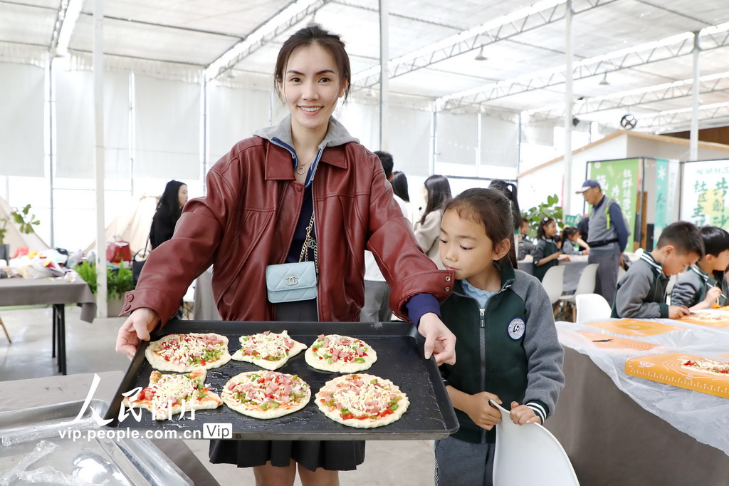 4月13日，家长展示学生们制作的披萨。