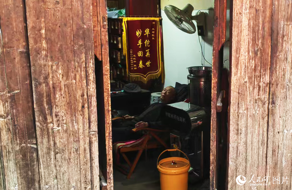 西河古镇，一位九旬老中医，看诊结束后，在躺椅上休息。