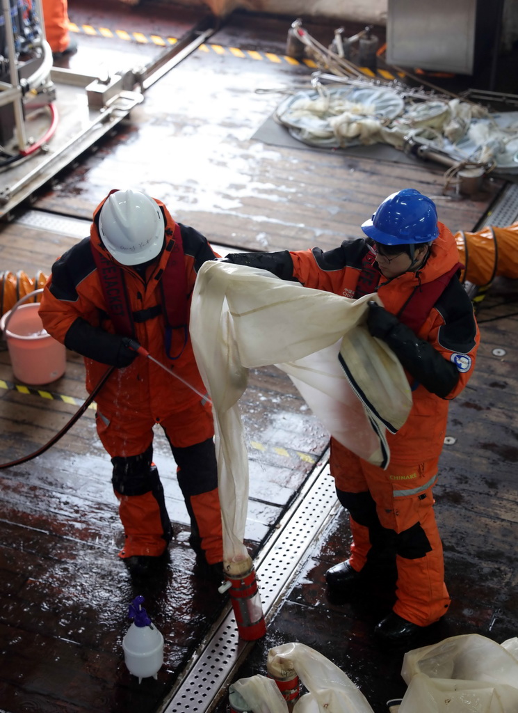 4月4日，科考队员在“雪龙2”号上冲洗浮游生物垂直网以获取样本。