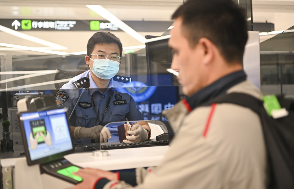 4月19日，乌鲁木齐出入境边防检查站民警为旅客办理入境手续。