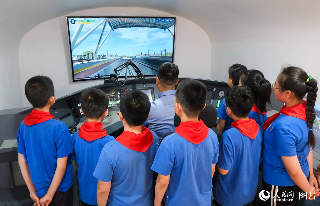 4月23日，学院老师为小学生们在实训中心演示模拟驾驶高铁动车。