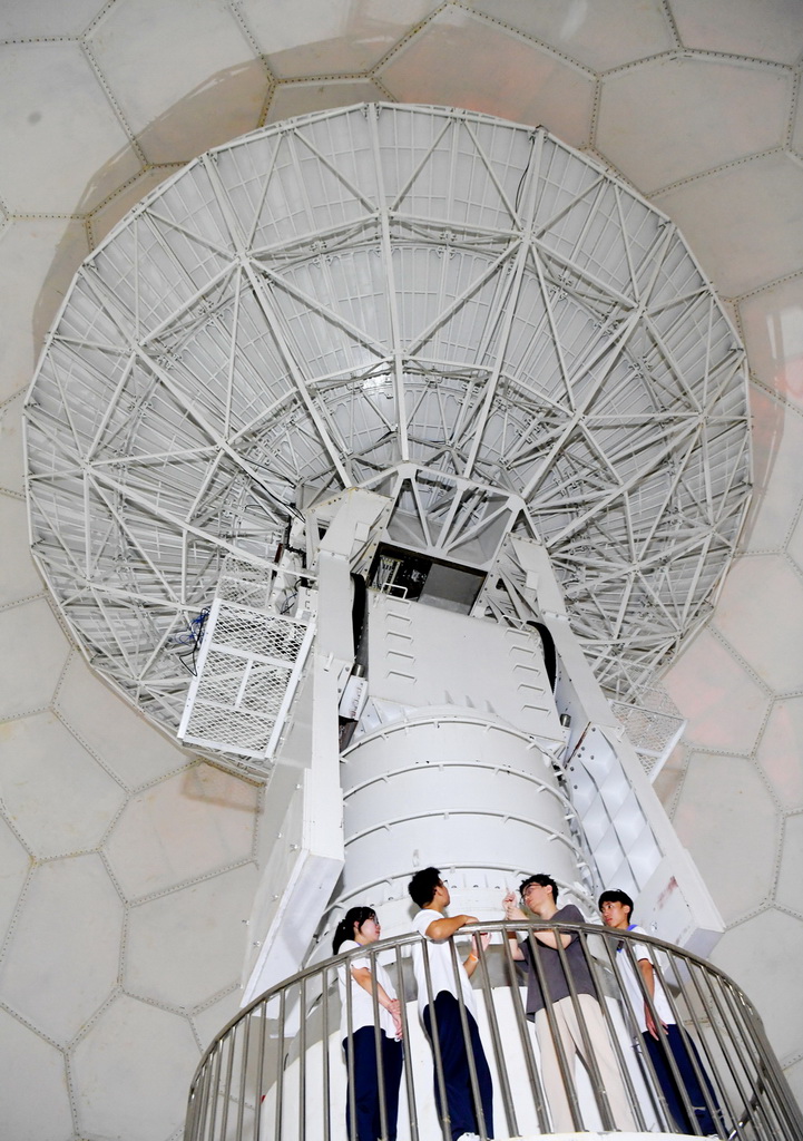 4月24日,在位于海南省三亚市的海南空天信息研究院,中央民族大学附属中学三亚学校的学生在卫星接收天线内部参观,了解其工作原理。新华社记者 赵颖全 摄
