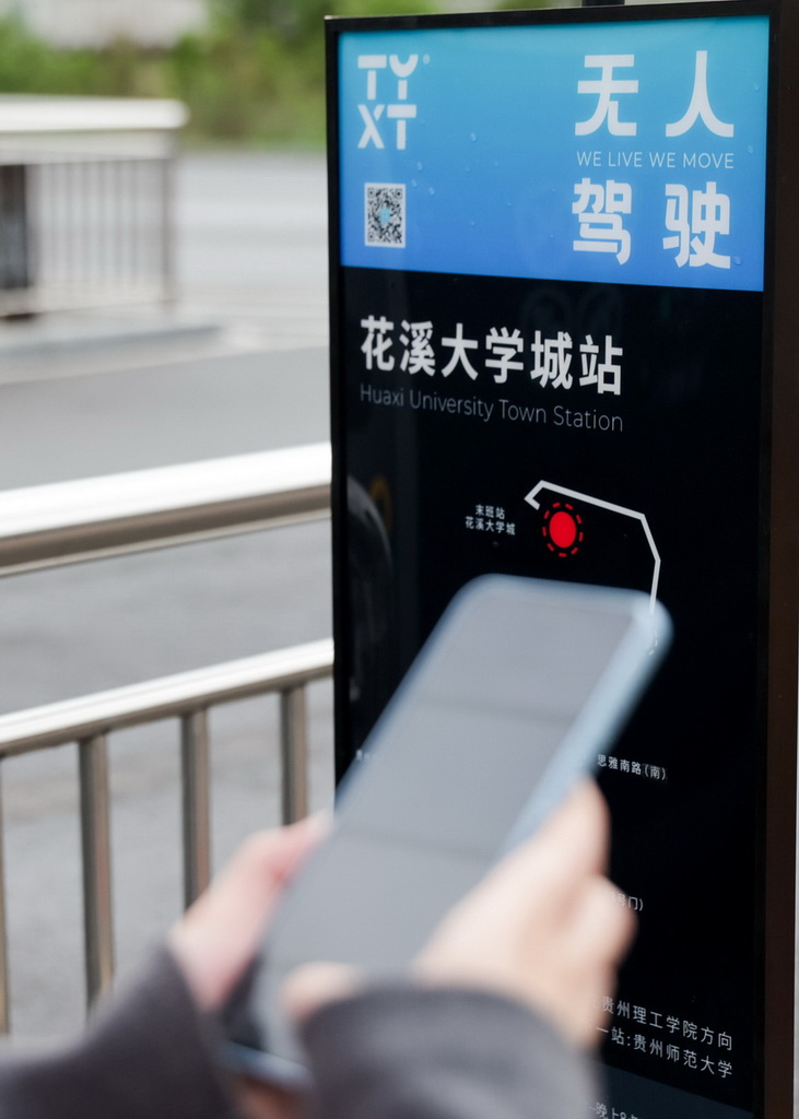4月24日，在贵阳市花溪大学城公交车站，前来参与体验活动的市民在扫码试乘无人驾驶公交车。新华社发（袁福洪摄）