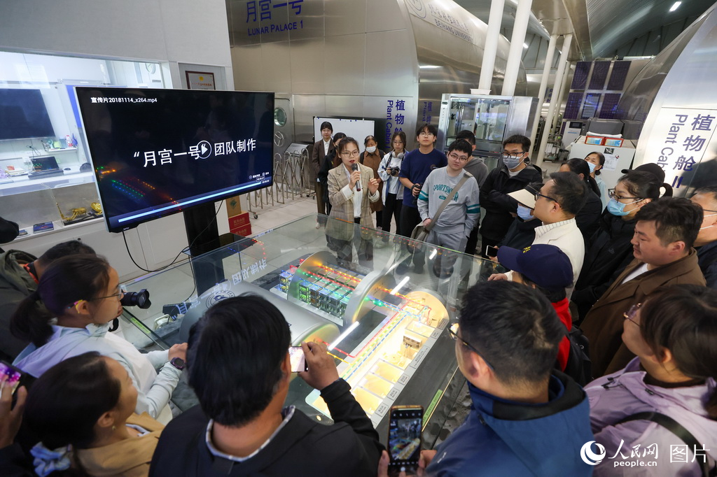 “月宫一号”团队的成员正在为观众讲解介绍“月宫一号”科普基地相关信息。