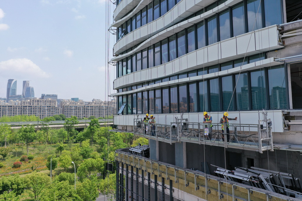 5月1日,中建四局建设者在浙江大学医学院附属妇产科医院钱江院区二期项目现场进行玻璃幕墙安装作业(无人机照片)。新华社记者 黄宗治 摄