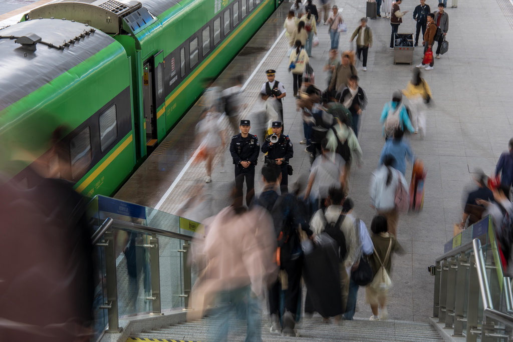 5月1日，乌鲁木齐铁路公安处乌鲁木齐站派出所民警在站台引导旅客安全乘车。新华社发（叶帅 摄）