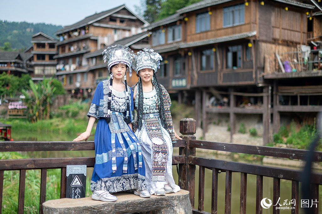 2025年5月3日，在广西三江侗族自治县程阳八寨景区，游客穿上民族服装合影留念。人民网记者 严立政摄