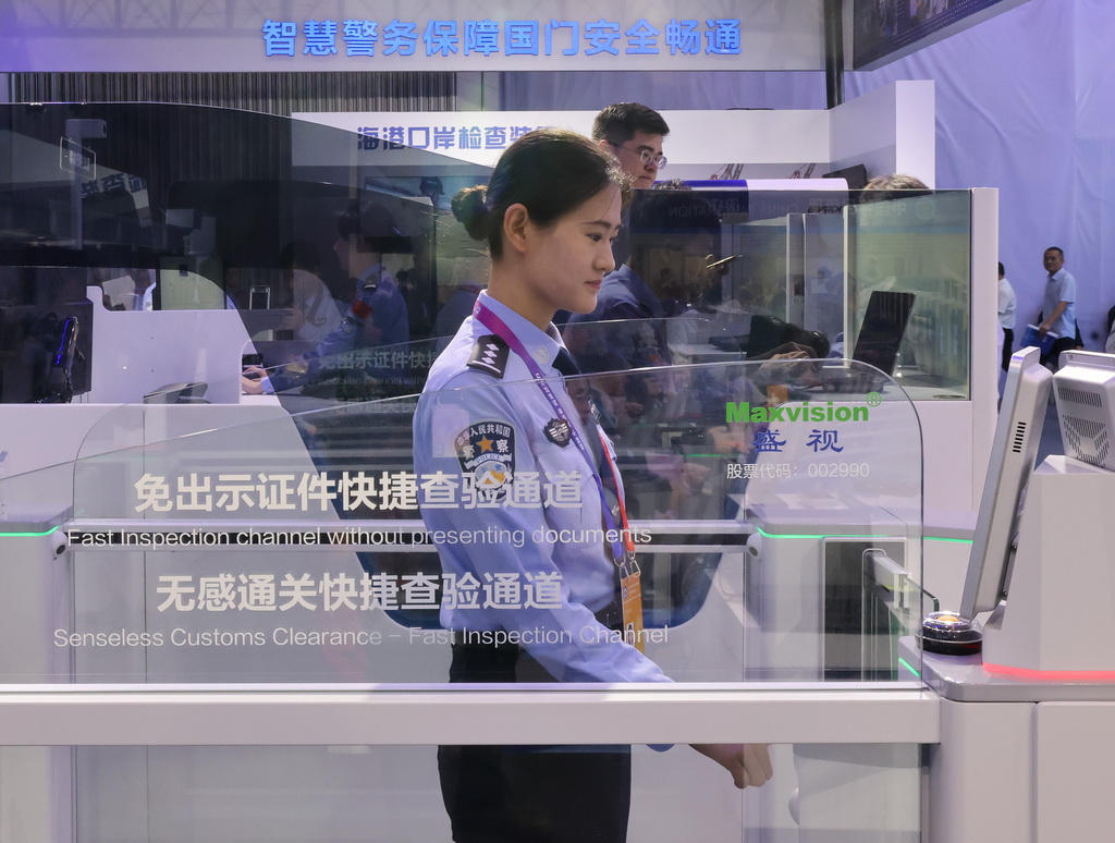 5月14日,在第十二届中国国际警用装备博览会移民管理装备展区,民警在体验免出示证件快捷查验通道。新华社记者 殷刚 摄