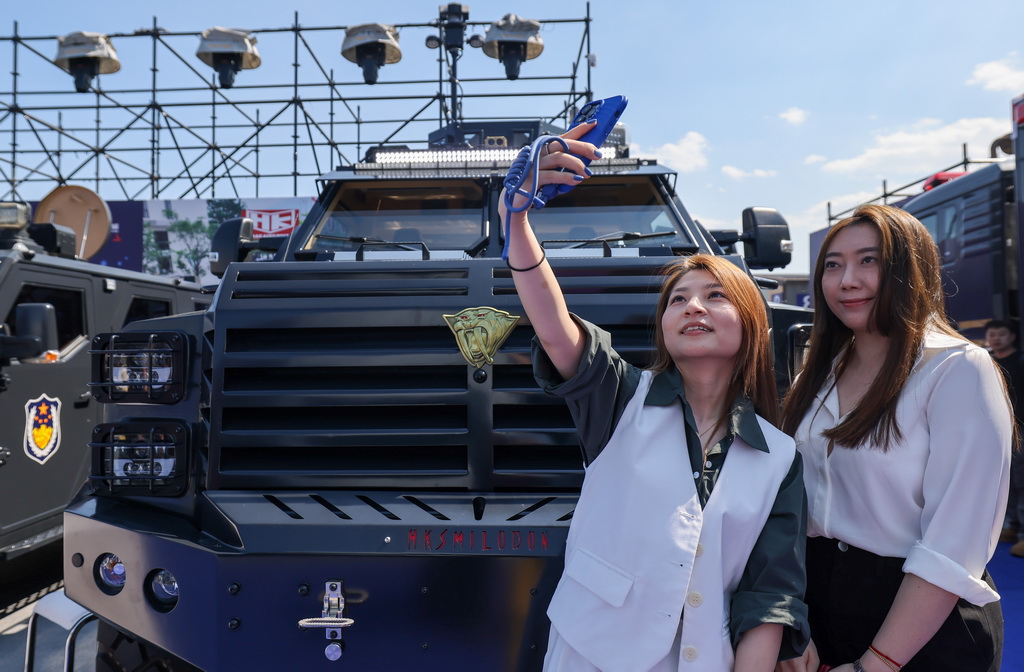 5月14日,在第十二届中国国际警用装备博览会上,观众在警用车前自拍留影。新华社记者 殷刚 摄