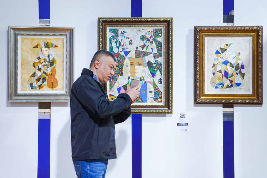 5月15日，参观者在主题油画作品展现场参观。