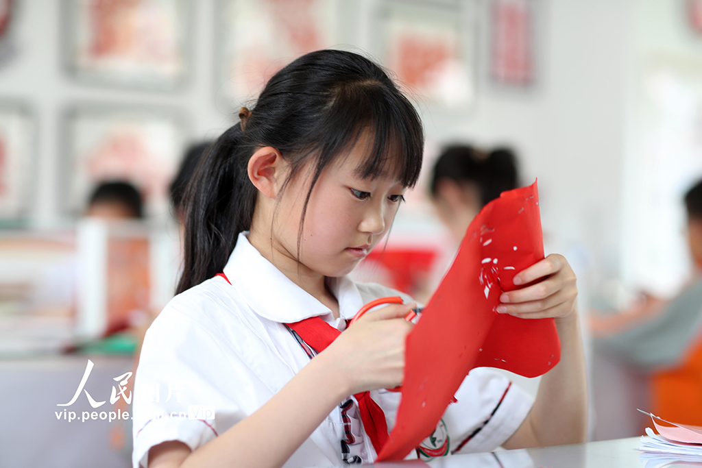 2025年5月17日，在陕西省旬邑县逸夫小学，学生学习剪纸。