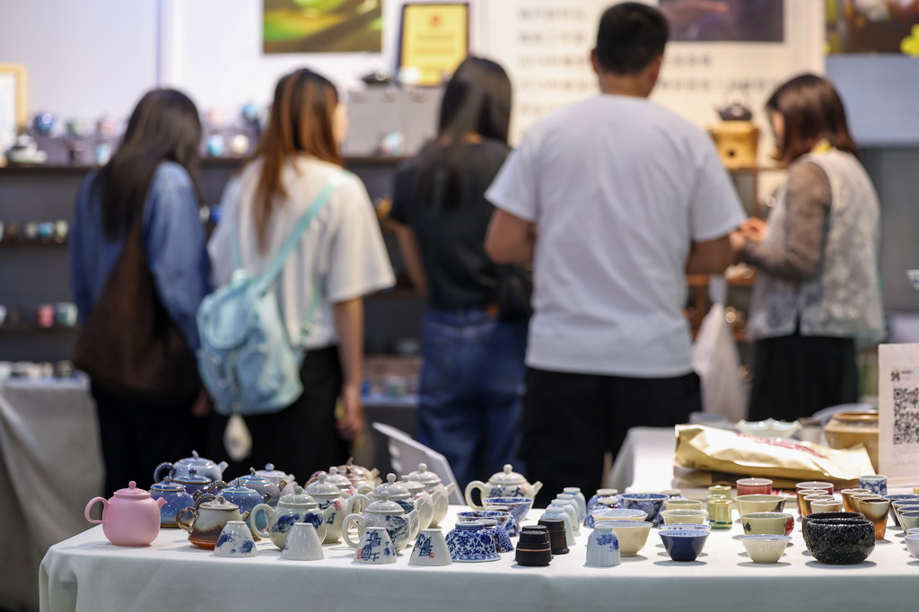 5月21日，观众在第七届中国国际茶叶博览会现场挑选茶器。